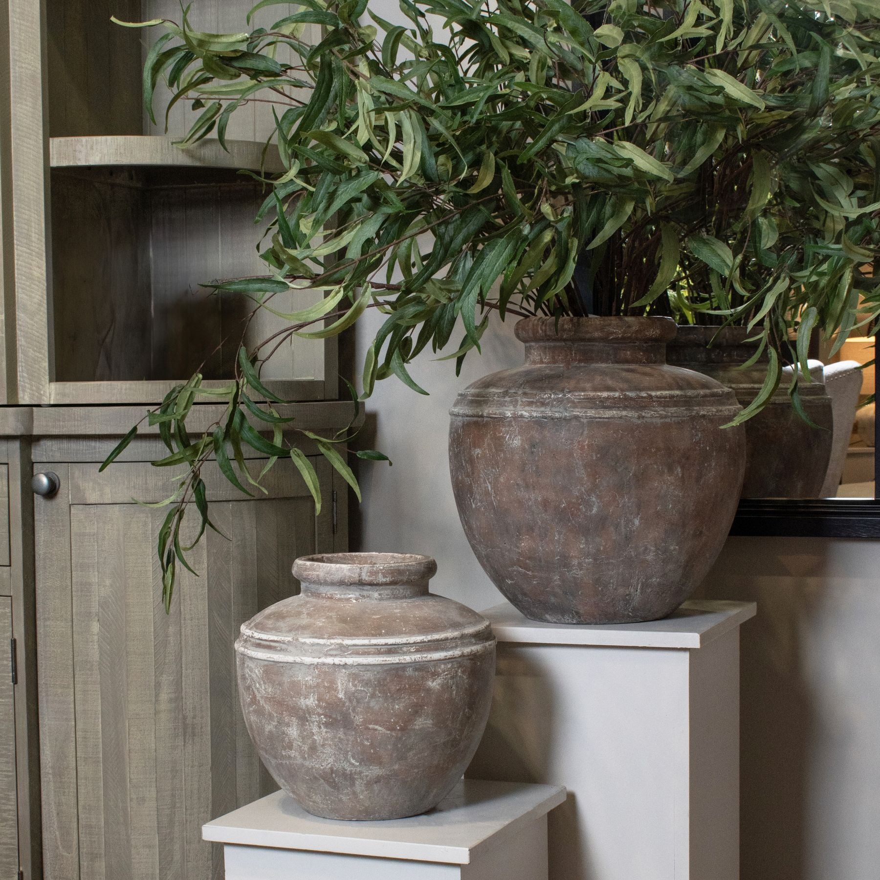 Lowther Stoneware Water Pot Planter styled in a neutral interior, placed near a corner with soft natural light highlighting its earthy matte glaze and sculptural vessel form.