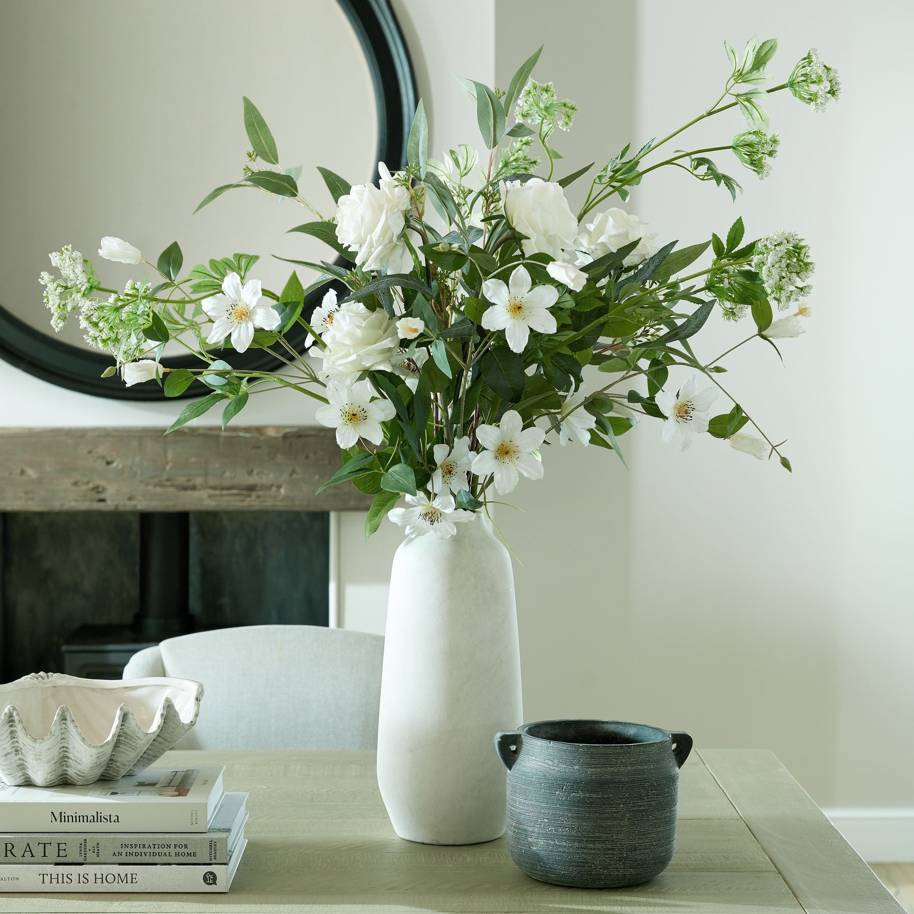 Ashbury Slate Hydria Ceramic Planter styled on a console table beneath a round mirror, paired with complementary stoneware vessels for a cohesive room vignette.