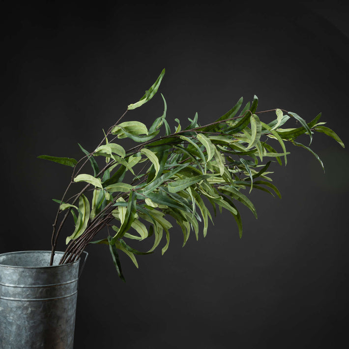Cluster of four Eucalyptus Nicholii Faux Foliage Spray stems grouped in a metal bucket vase against a dark backdrop, creating a lush, dimensional display.