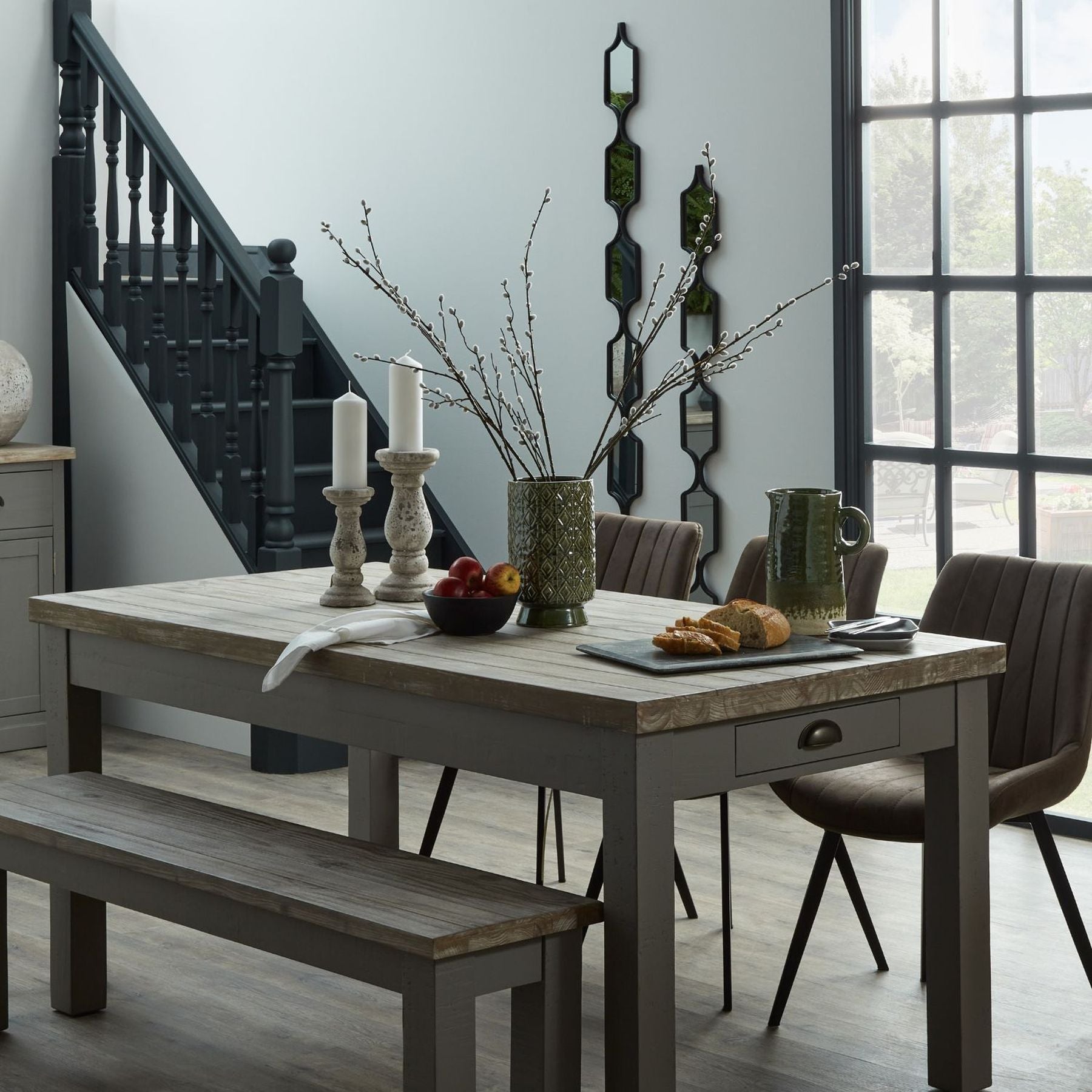 Lifestyle image of grey ceramic candle holder on wooden mantel with soft candle glow