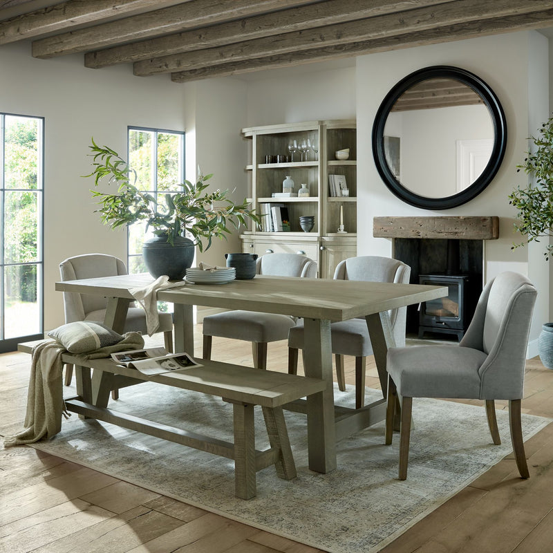 Seeded Eucalyptus Faux Spray arranged in a ceramic vase on a dining table within a light-filled, contemporary interior.