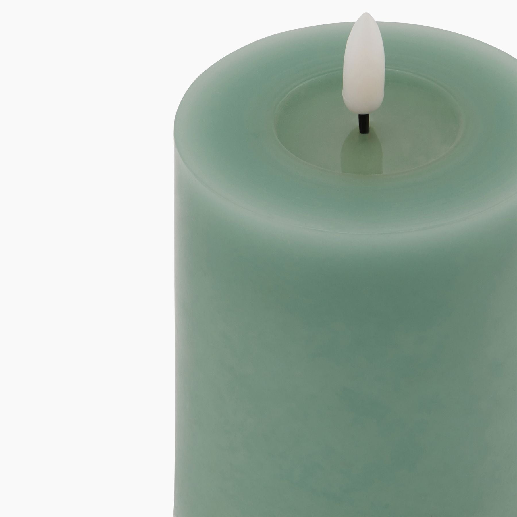 Lit Signature Melt-Effect Sage LED Candle in a styled interior setting, highlighting the warm flickering glow and detailed wax drip effect