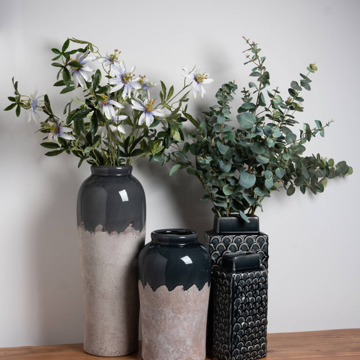 Rectangular ceramic vase with glossy slate-blue glaze and shell-pattern relief, ideal for styling dried stems or as a sculptural shelf accent.