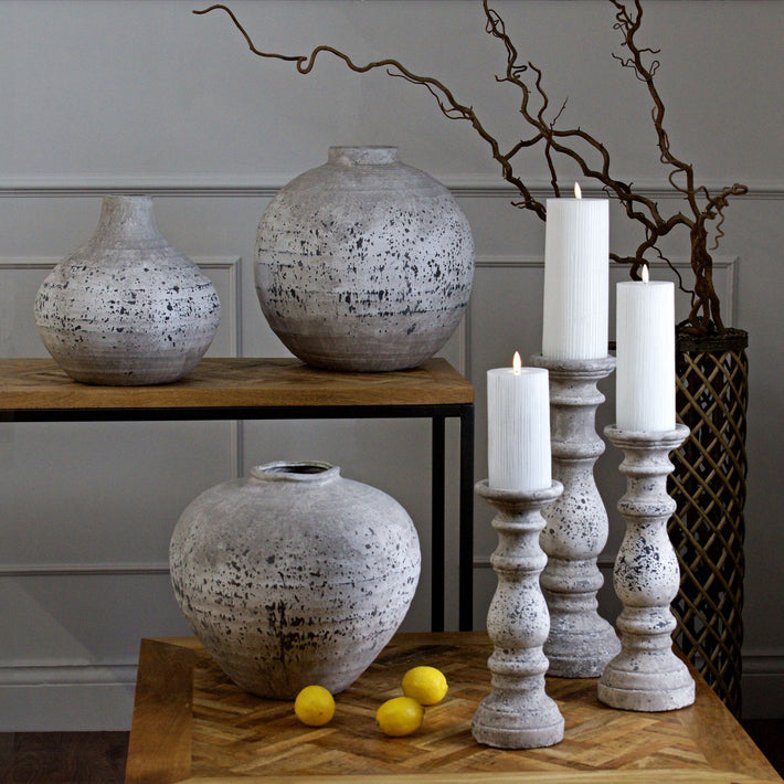 Small ceramic globe vase with textured stone-effect glaze, ideal for styling with dried stems or sculptural display in rustic interiors.