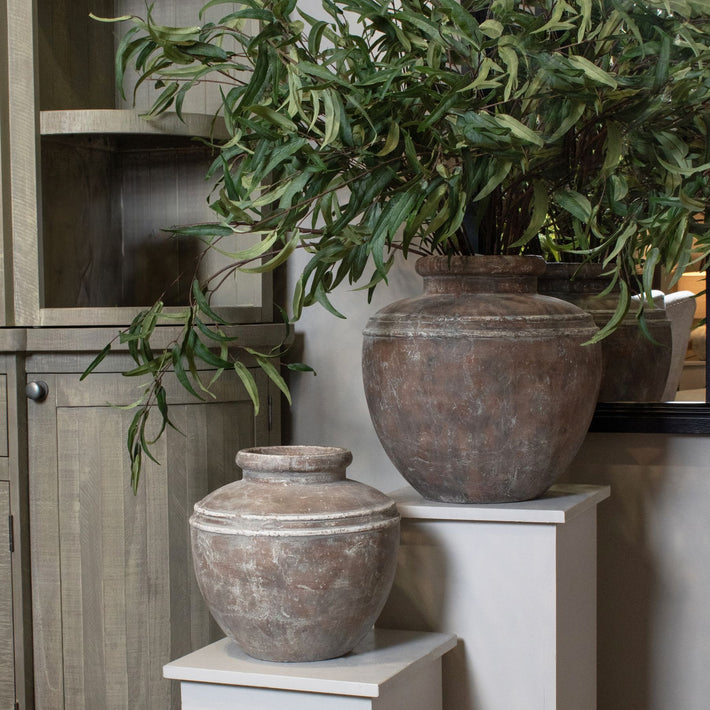 Lowther Stoneware Water Pot Planter styled in a neutral interior, placed near a corner with soft natural light highlighting its earthy matte glaze and sculptural vessel form.