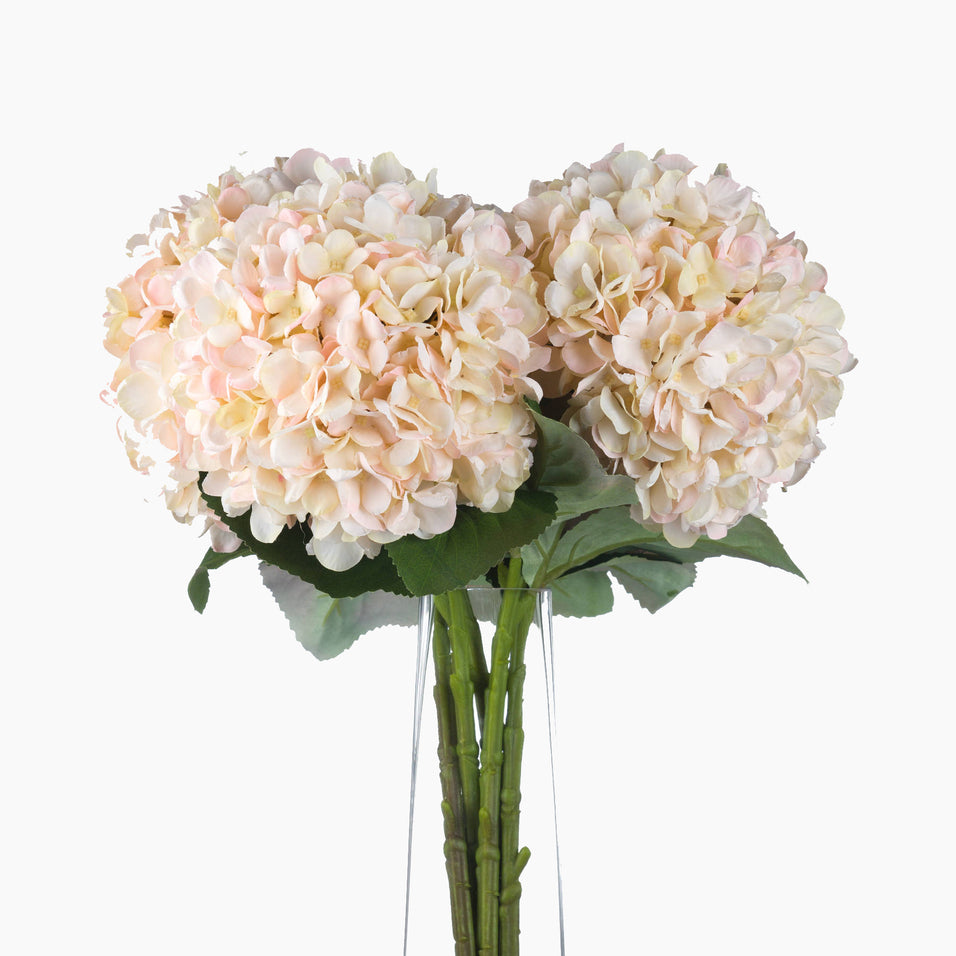 Front-facing view of single faux hydrangea stem with layered petals and long stem