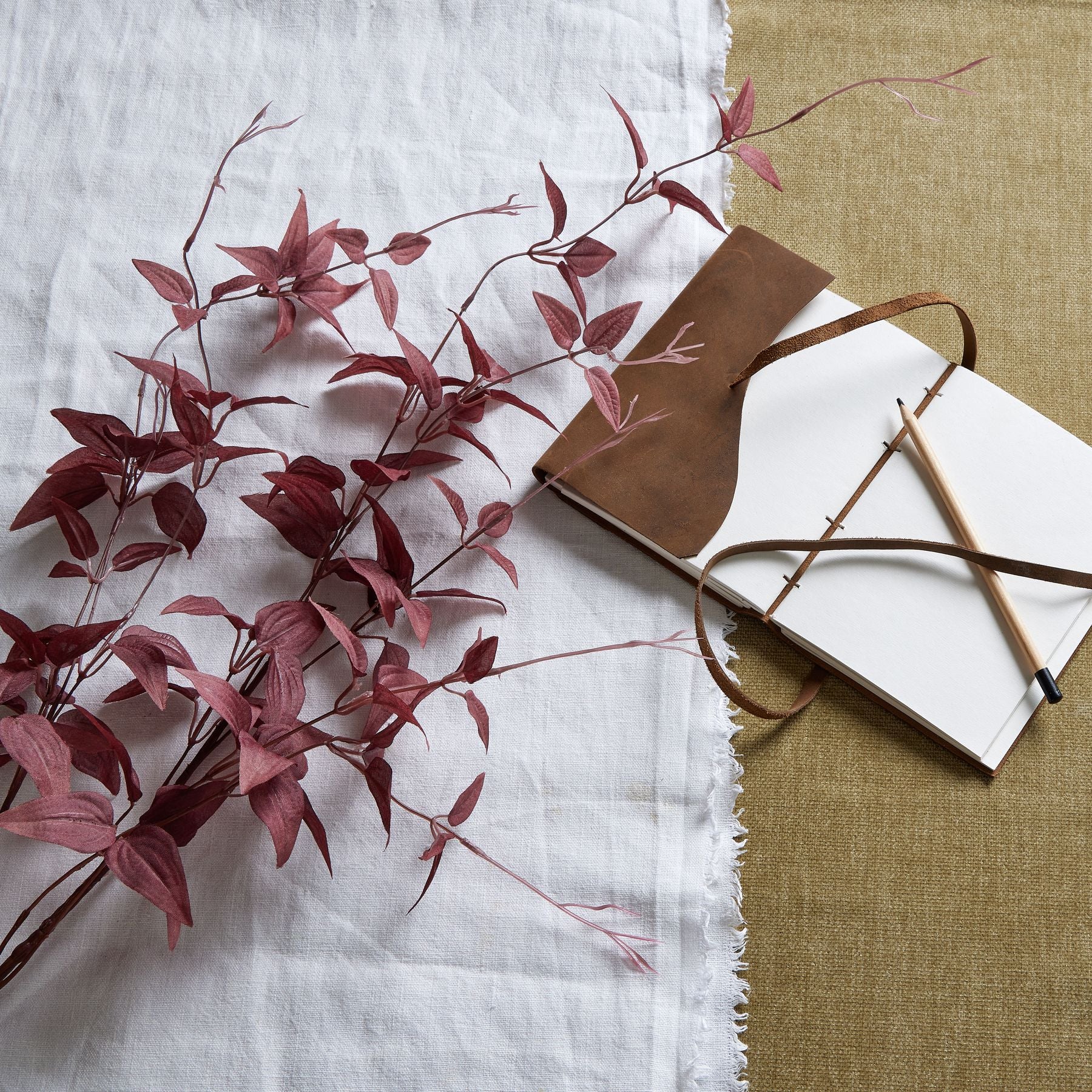 Angled view of burgundy leaf faux branch, deep wine-red foliage crafted from resin and fabric for sculptural room styling