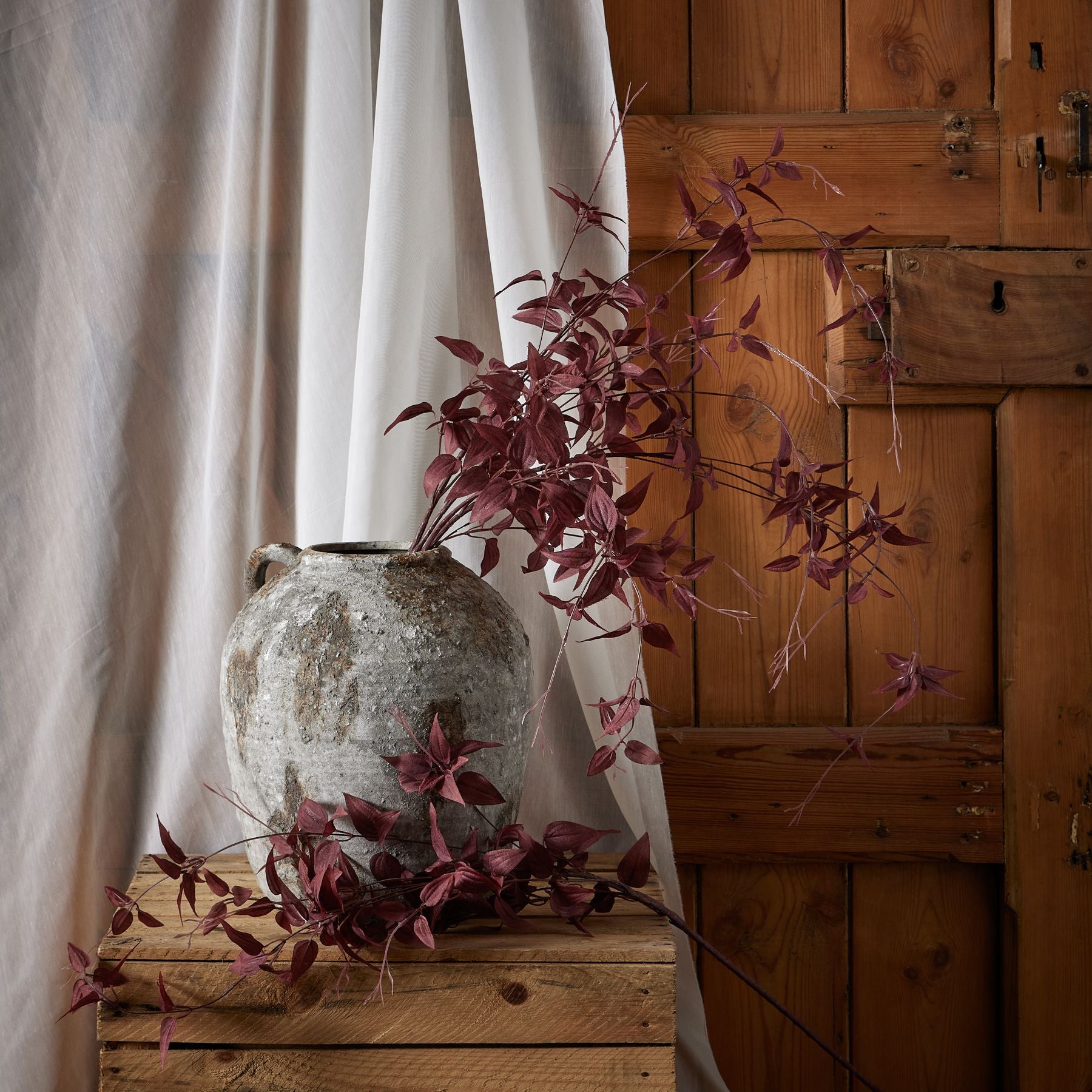 Overhead view of burgundy leaf faux branch showing branching structure and lifelike artificial foliage texture