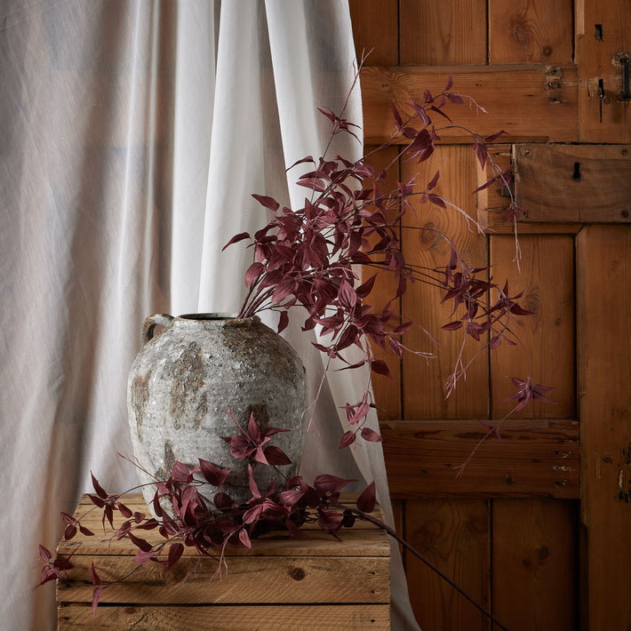 Overhead view of burgundy leaf faux branch showing branching structure and lifelike artificial foliage texture