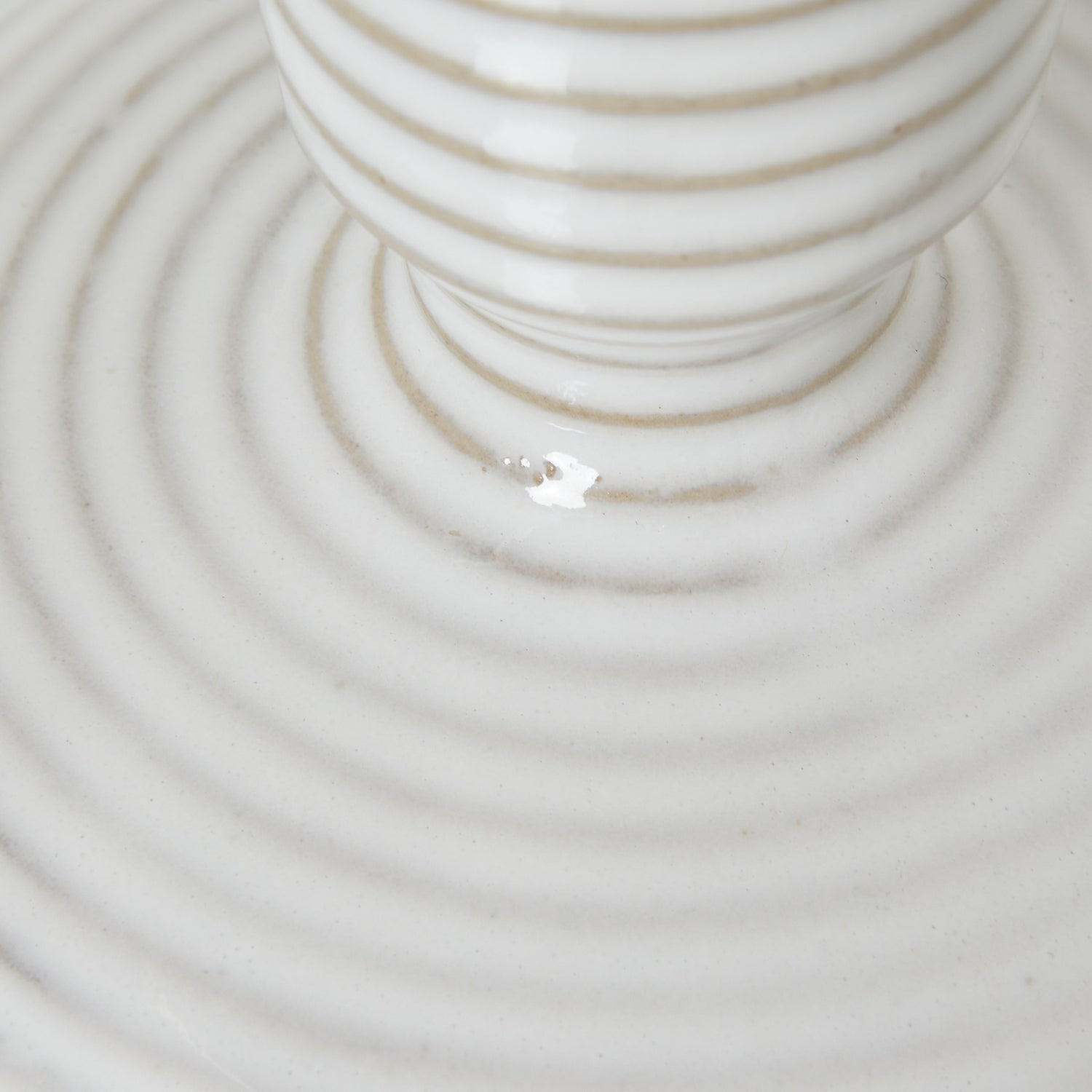 Angled close-up of ceramic taper holder showing ridged texture and soft matte glaze in neutral white
