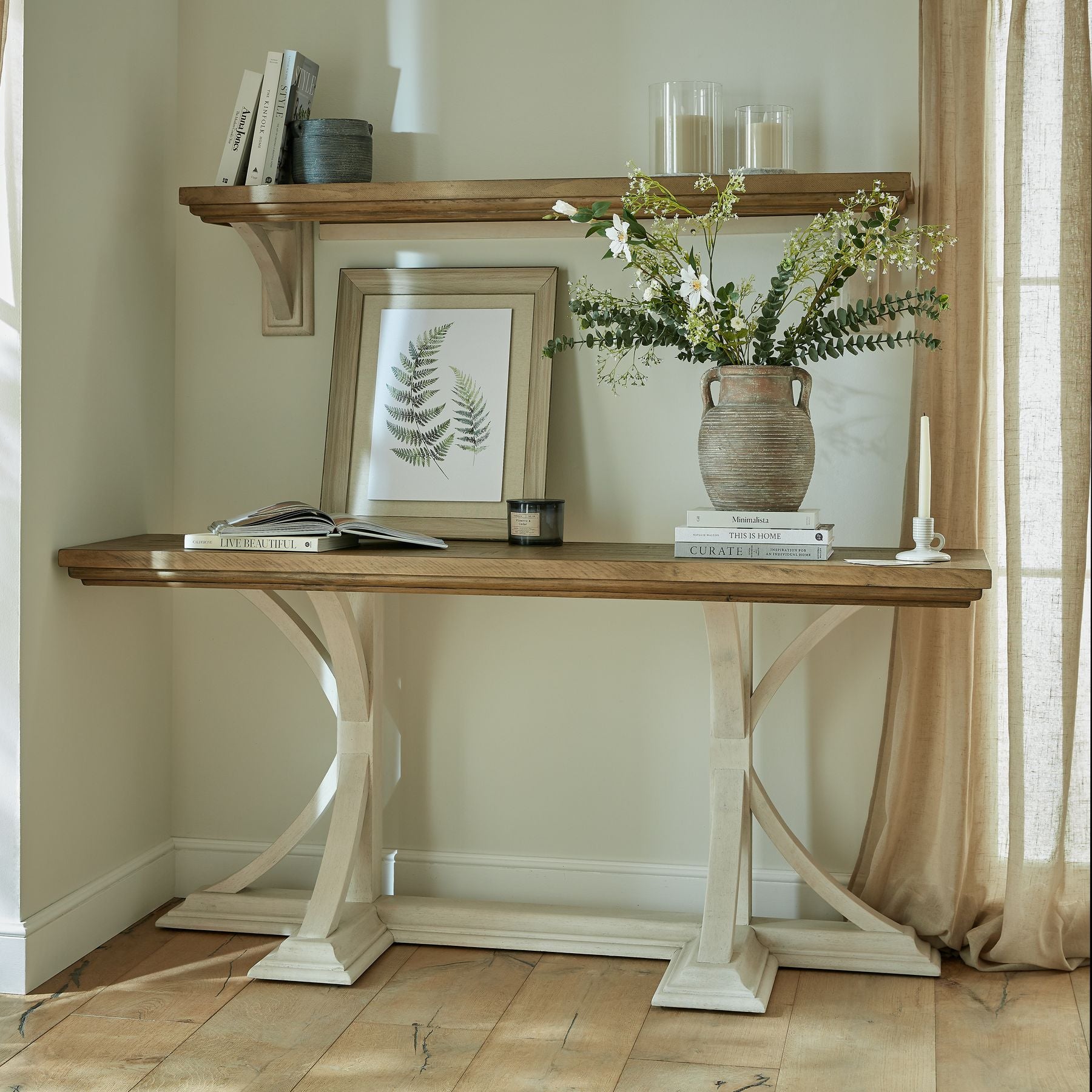 Lifestyle image of the Lowther Amphora Stoneware Vase styled with faux branches on a console table.