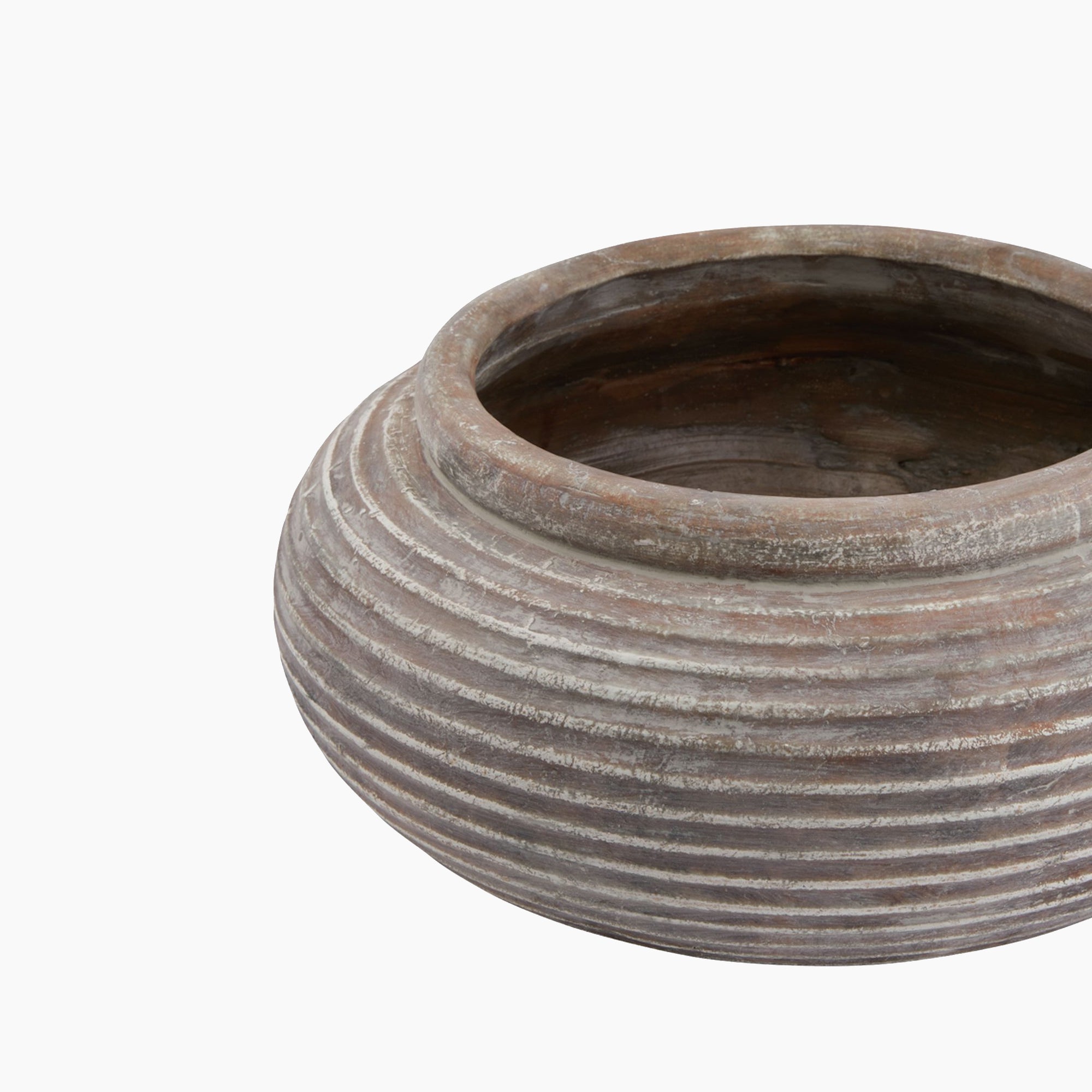 Angled view of the Lowther Ribbed Stoneware Bowl Planter showing its wide mouth, ribbed sides, and weathered clay finish. Sculptural form with soft shadowing.
