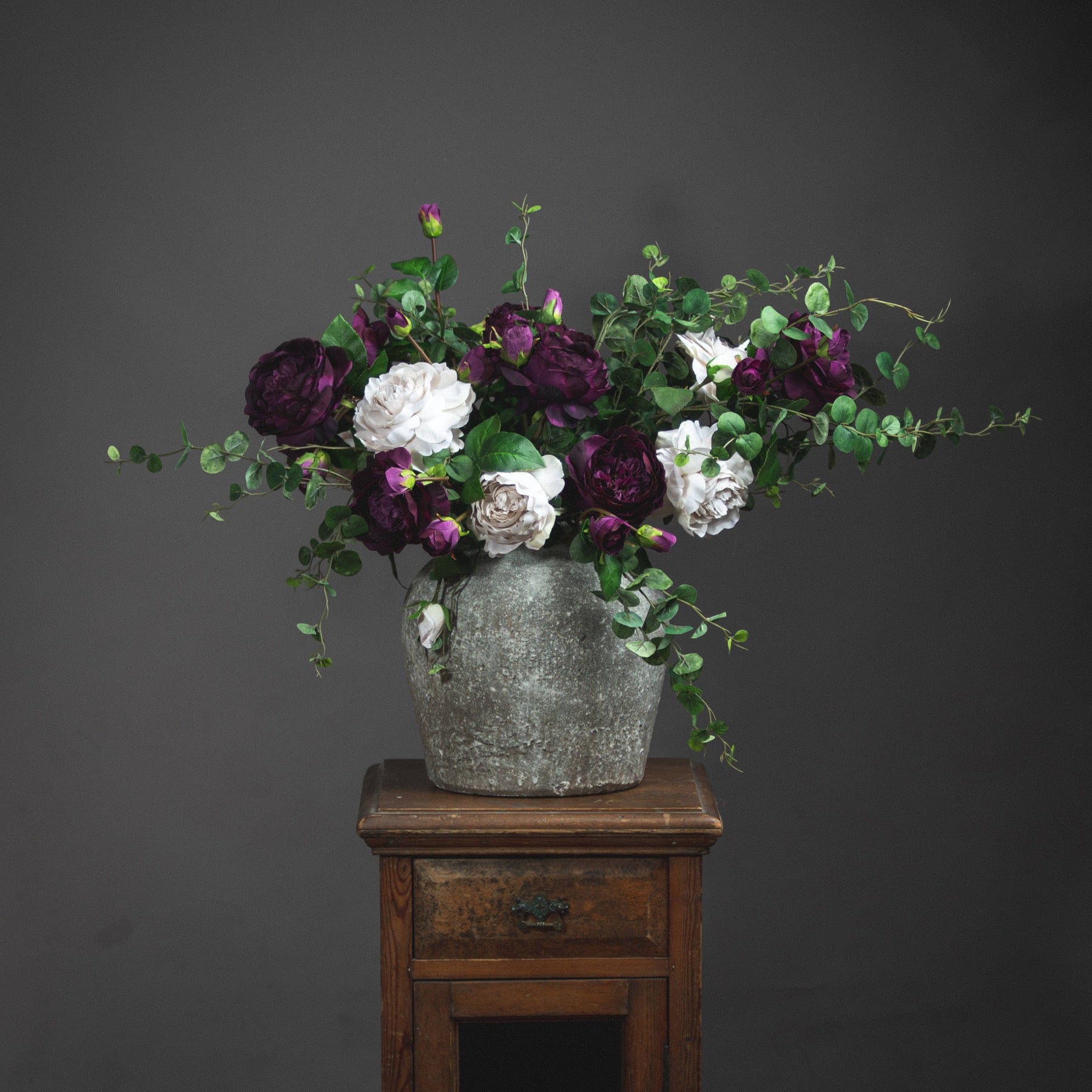 Rudlow stone-grey urn vase styled with mixed faux peonies and eucalyptus.