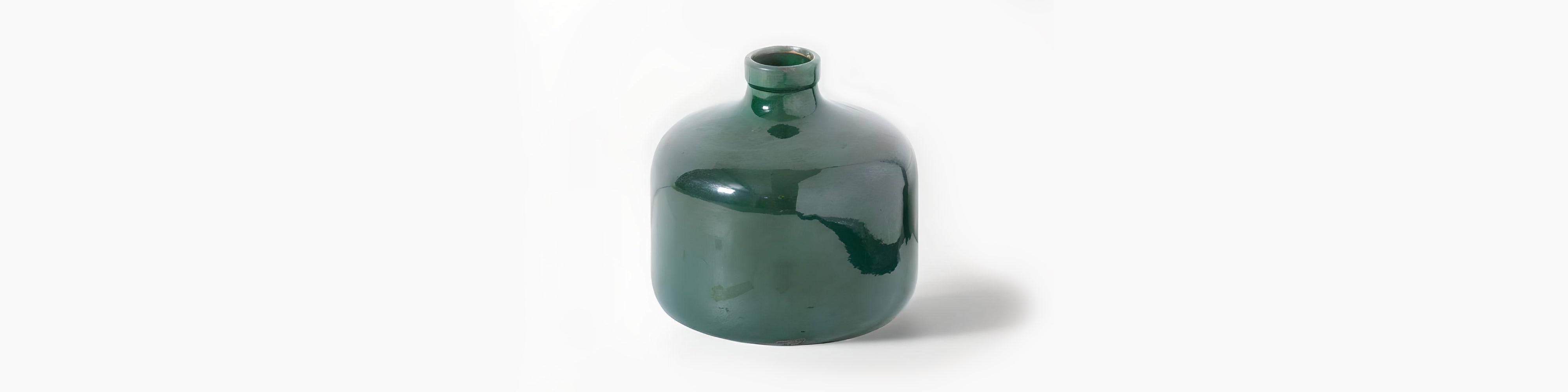 Signature Curated Room Kit banner featuring an emerald green glazed ceramic vase styled in a minimalist brutalist-Scandi interior by Christie’s Interior
